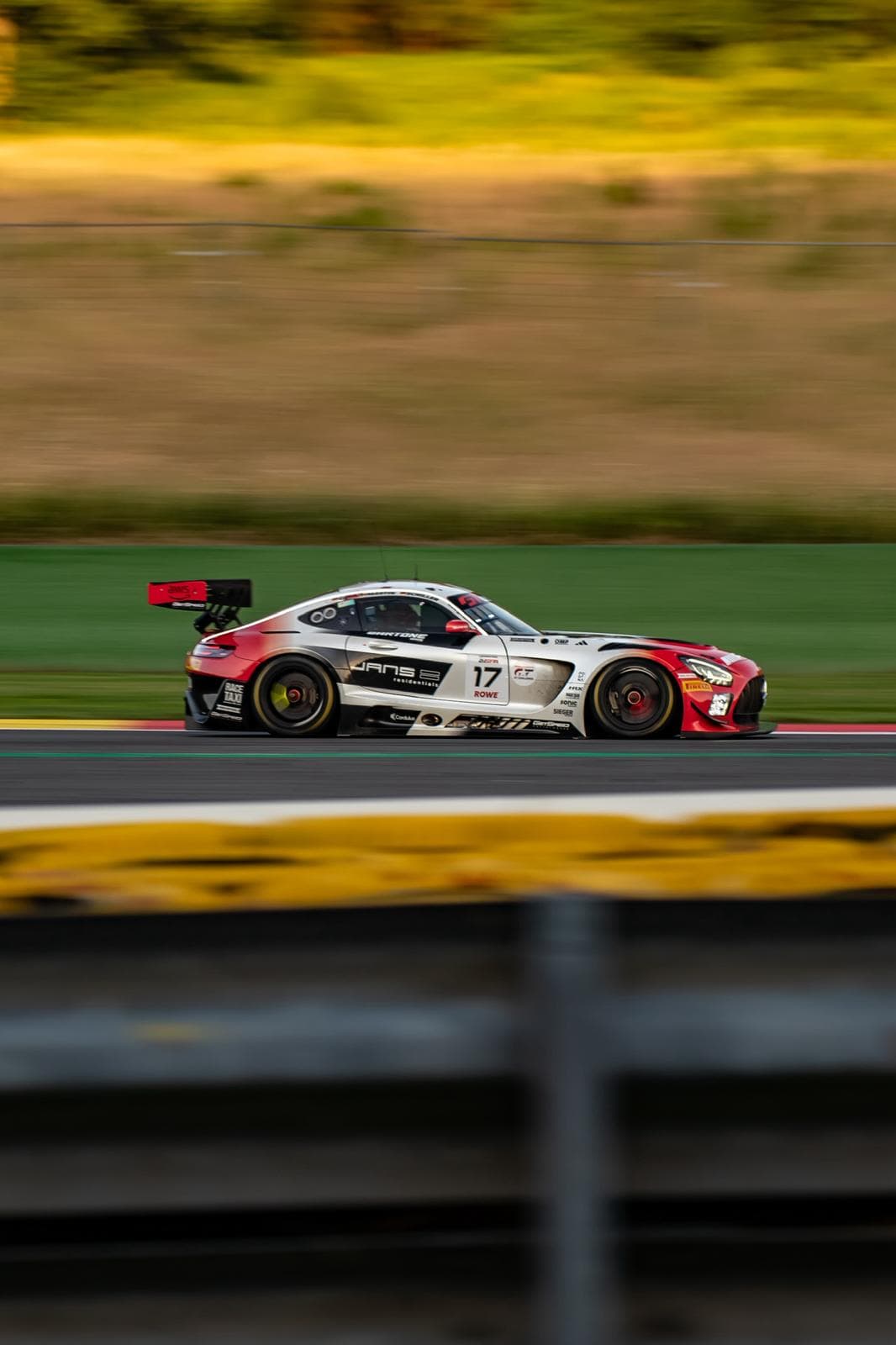 Voiture de course rouge et blanche passant sur les vibreurs jaunes