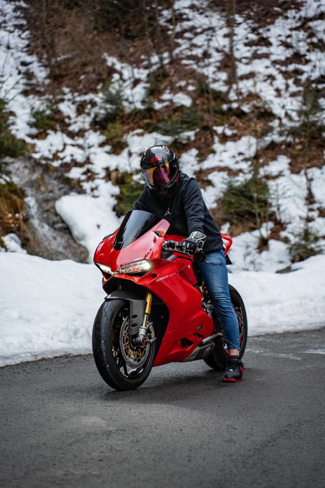 Moto Ducati Panigale rouge de profil sur une route enneigée