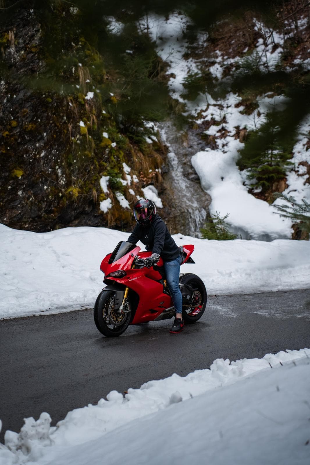 Moto Ducati Panigale rouge inclinée dans un virage bordé de neige