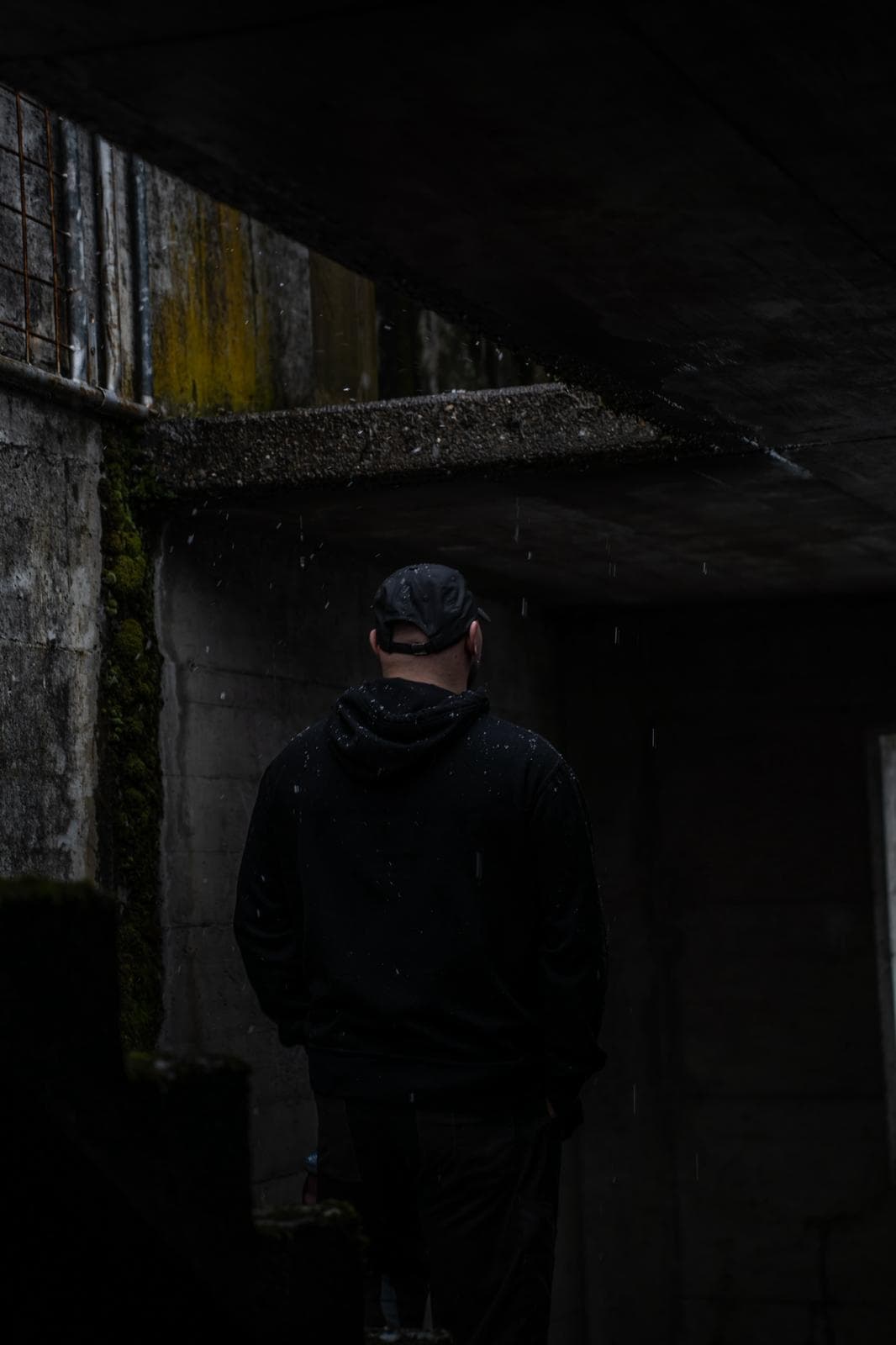 Silhouette d'un homme de dos dans une structure de béton sombre